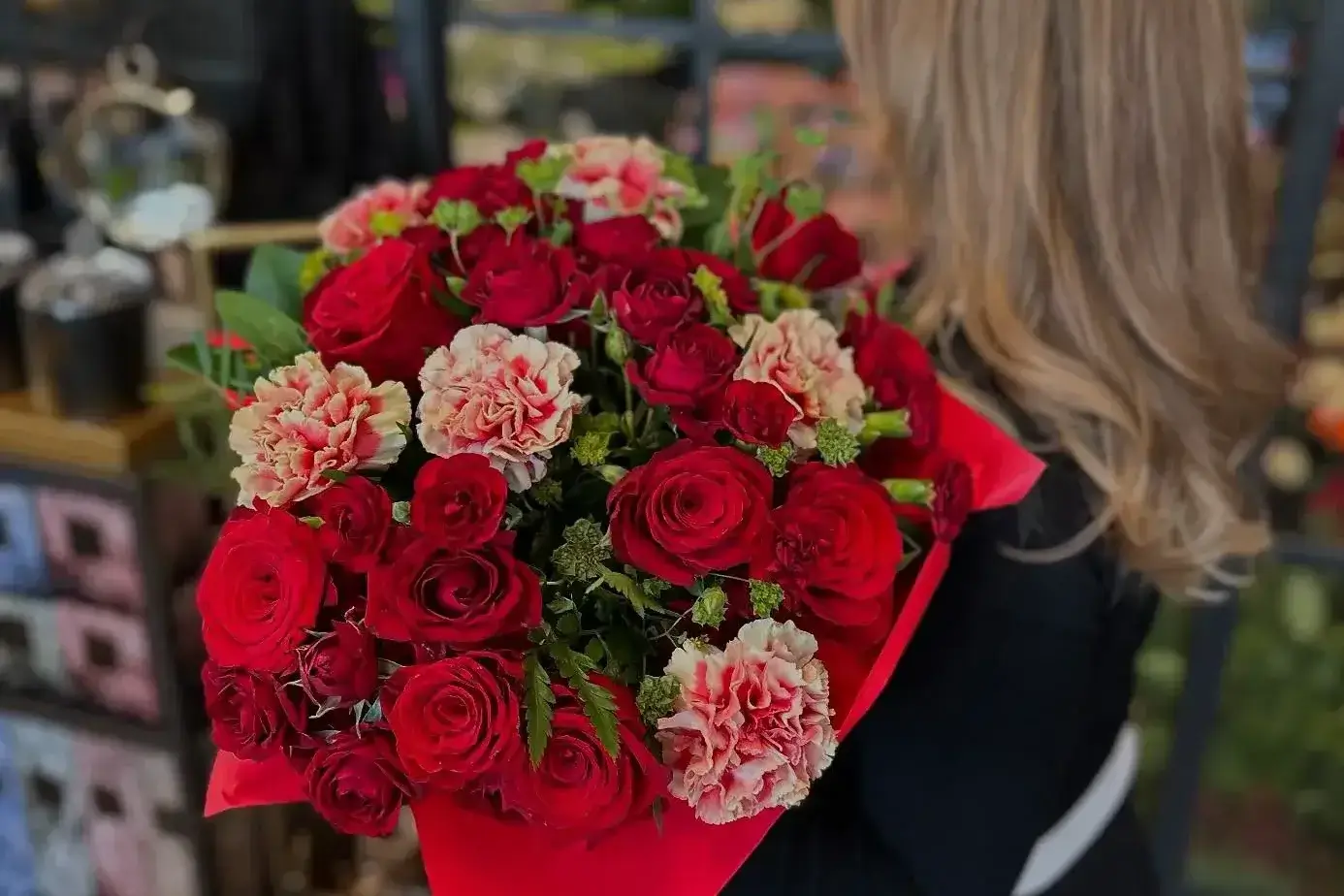 Kobieta trzymająca elegancki, czerwony bukiet kwiatów