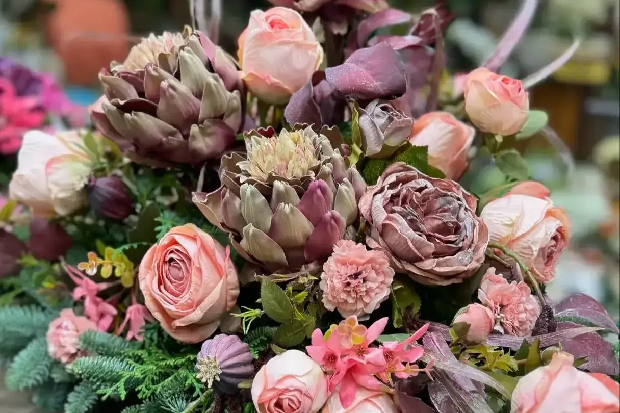 Kompozycja kwiatowa z różami i dekoracyjnymi elementami roślinnymi