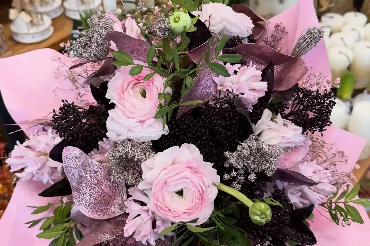 Nowoczesny bukiet w odcieniach różu i fioletu, trzymany w dłoni